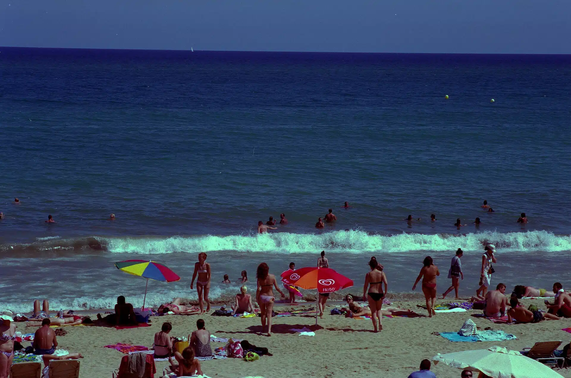 Strand i Barcelona med badgäster en solig dag