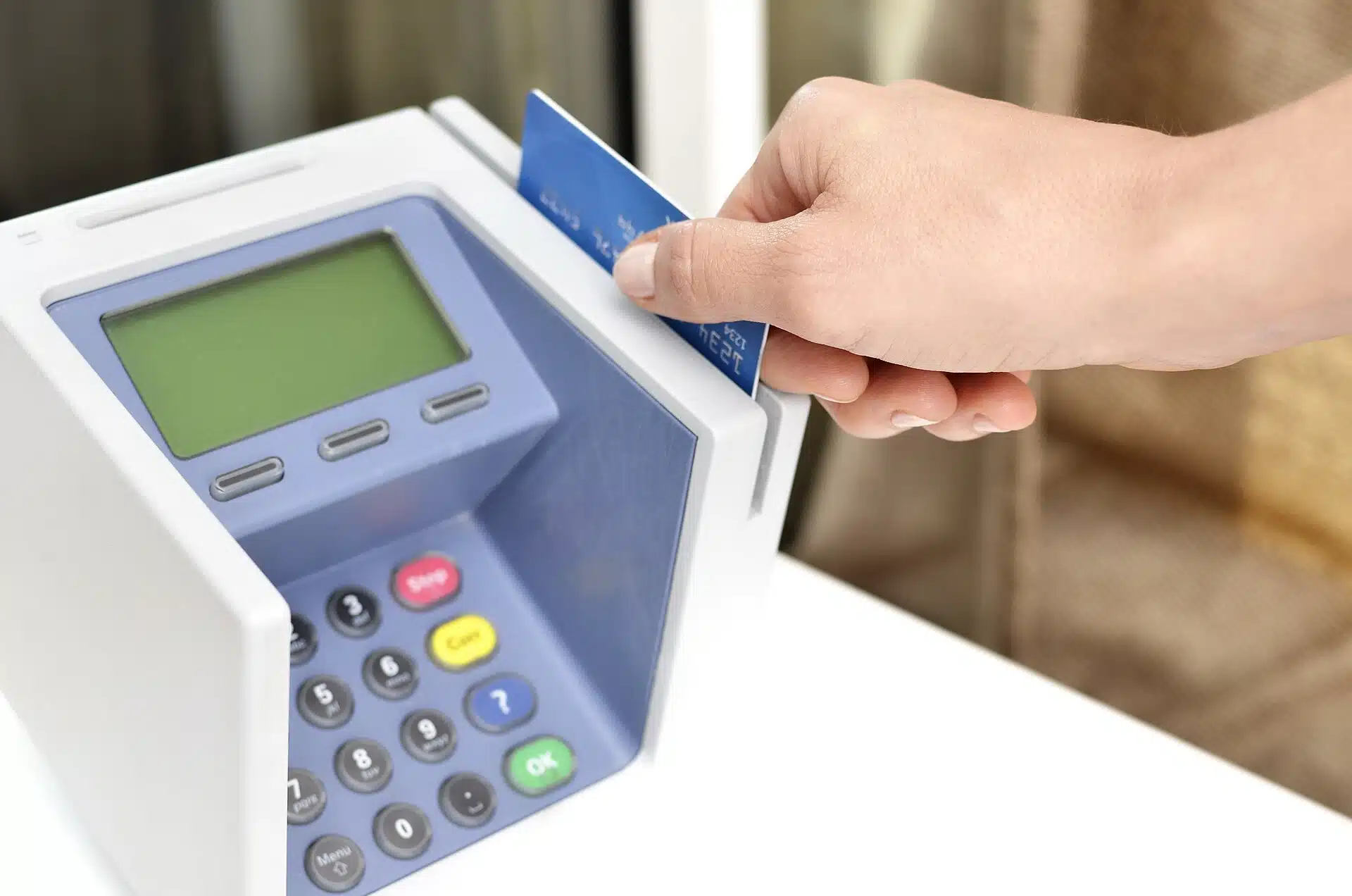 En hand för in ett betalkort i en betalterminal på en disk