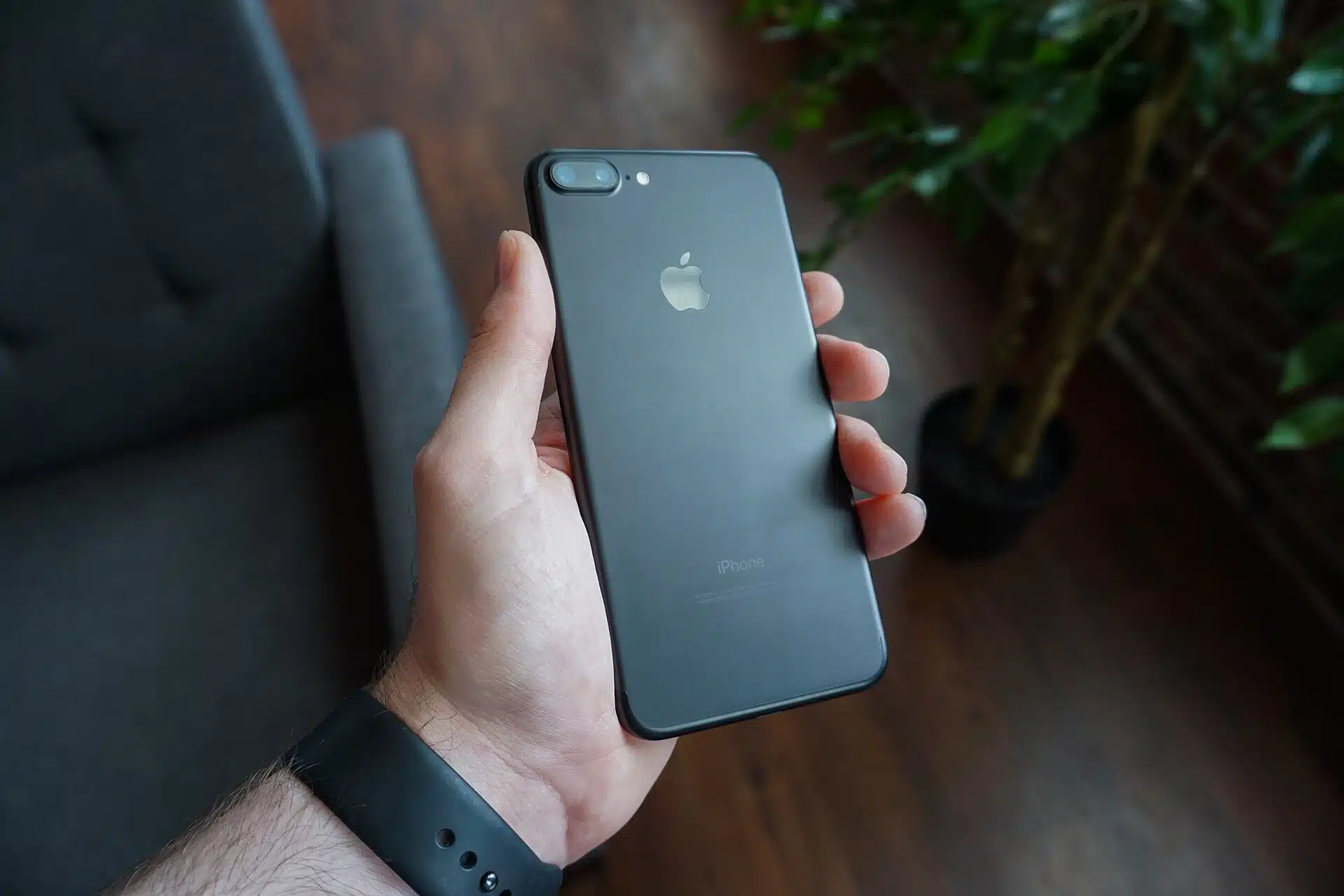 En hand håller en svart mobiltelefon