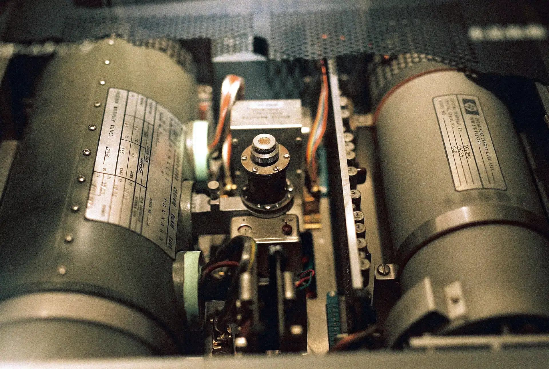 Insidan av ett atomur med metallcylindrar och elektronik